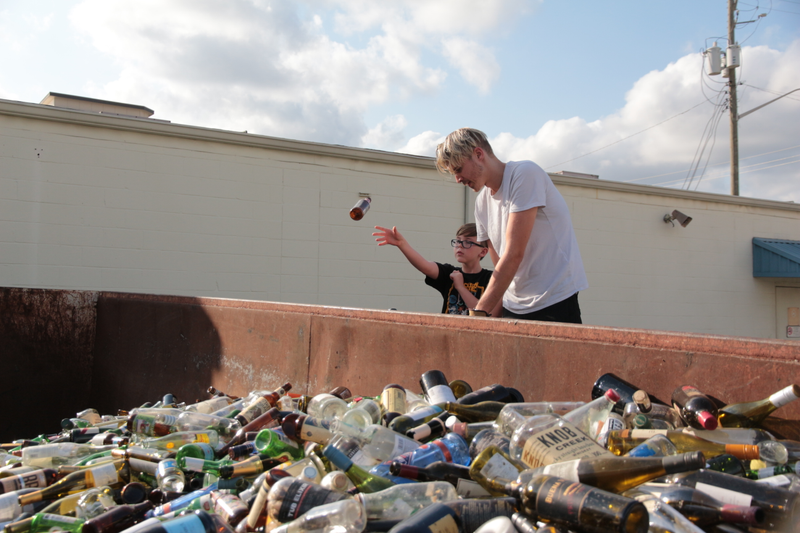 Tristan “Pan” Berlanga tosses a glass bottle into into a metal bin the size of an 18-wheeler on an empty lot owned by Pan’s father.